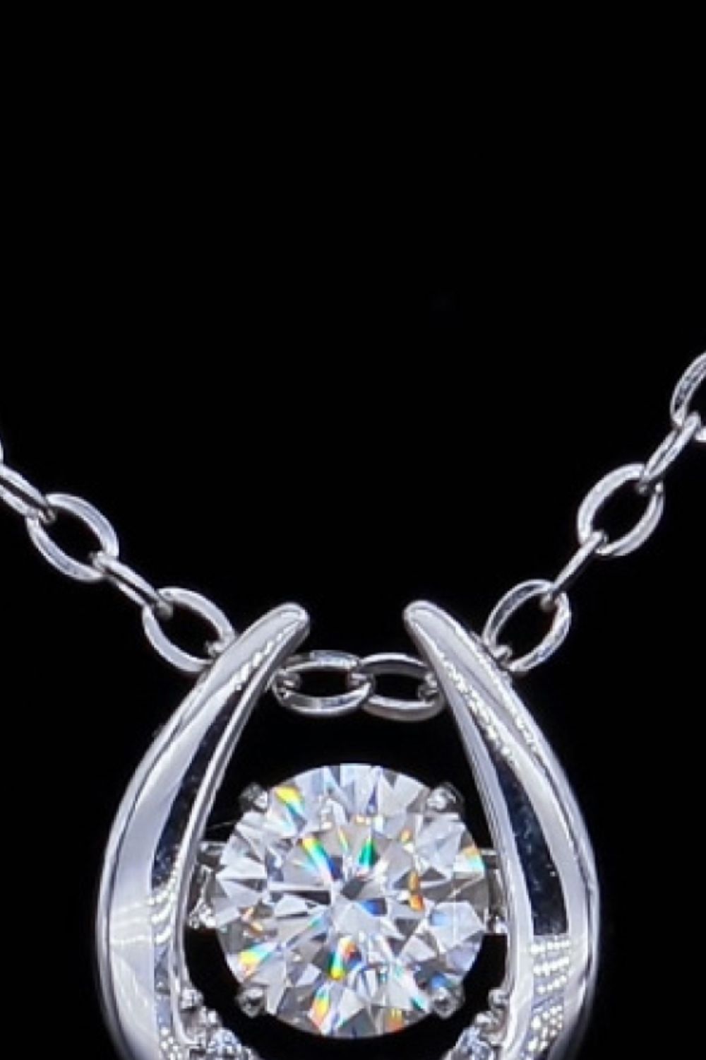 Silver necklace with a round brilliant cut diamond in a halo setting.