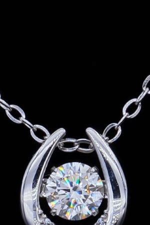Silver necklace with a round brilliant cut diamond in a halo setting.
