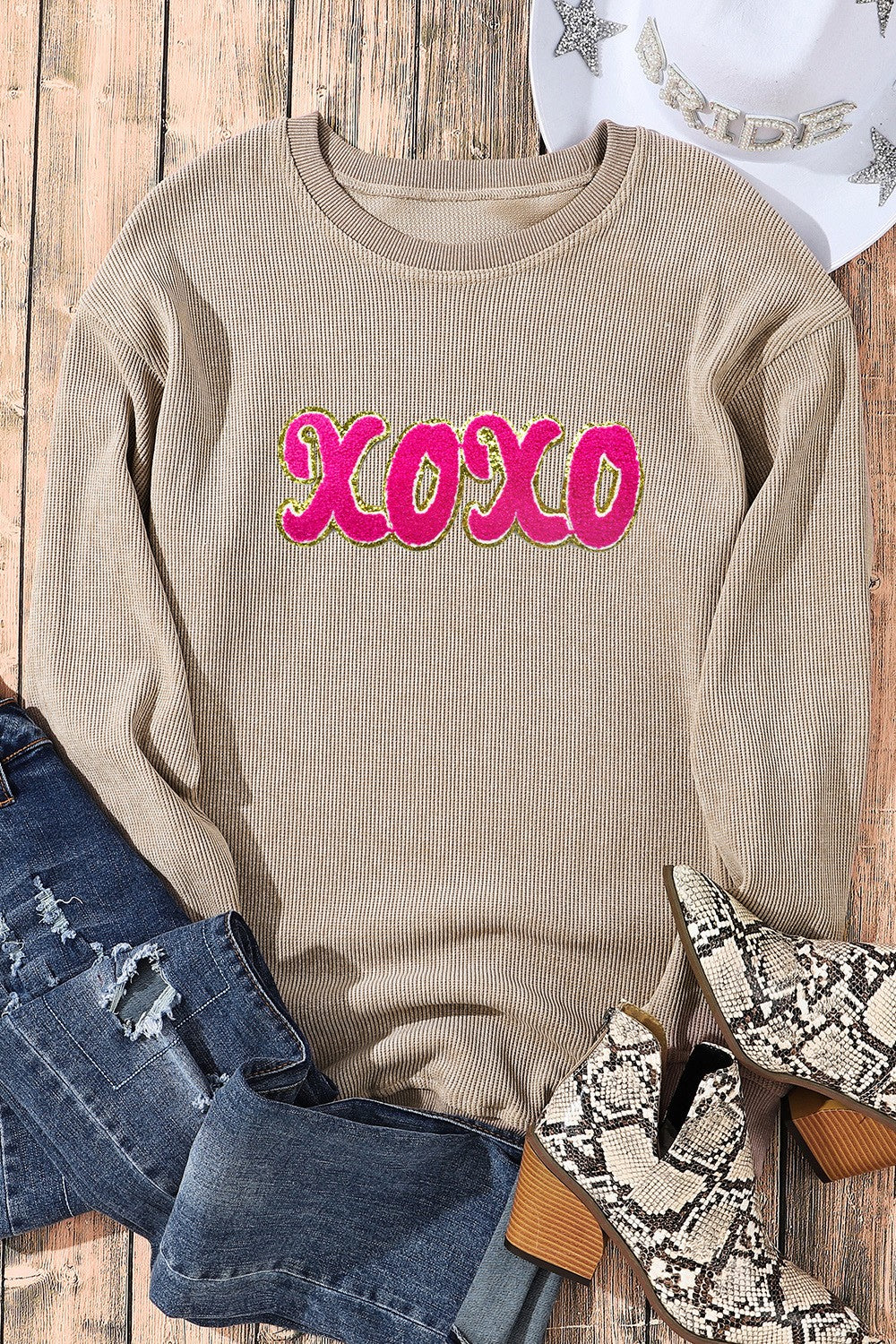 Tan ribbed sweatshirt with pink XOXO appliqué and gold trim