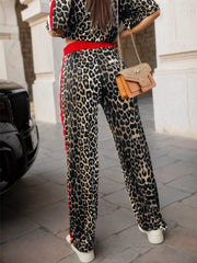 Leopard print lounge pants with red stripe detail and elastic waist, paired with a matching crop top.