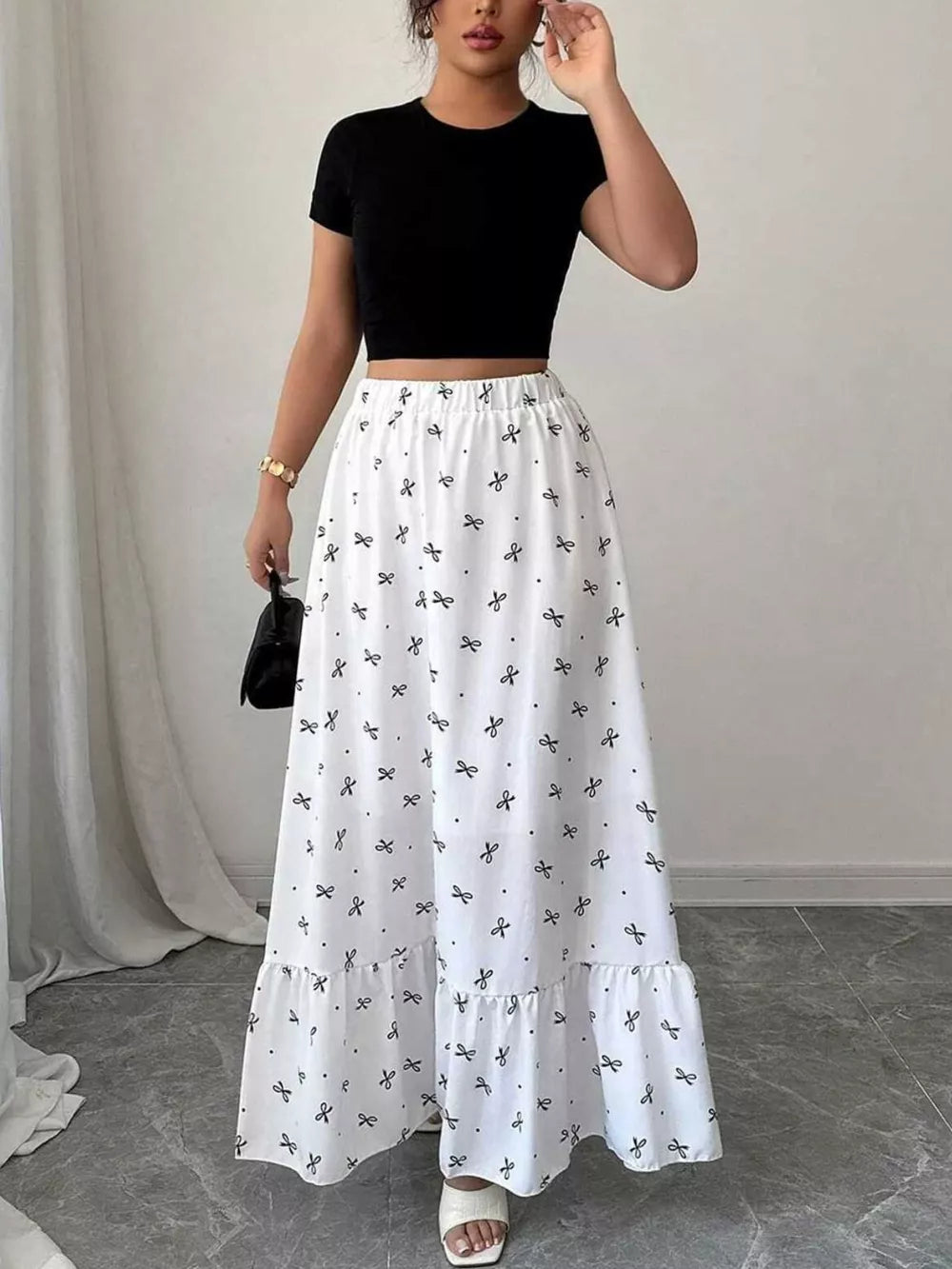 White maxi skirt with black bowknot print and ruffled hem, elastic waist.