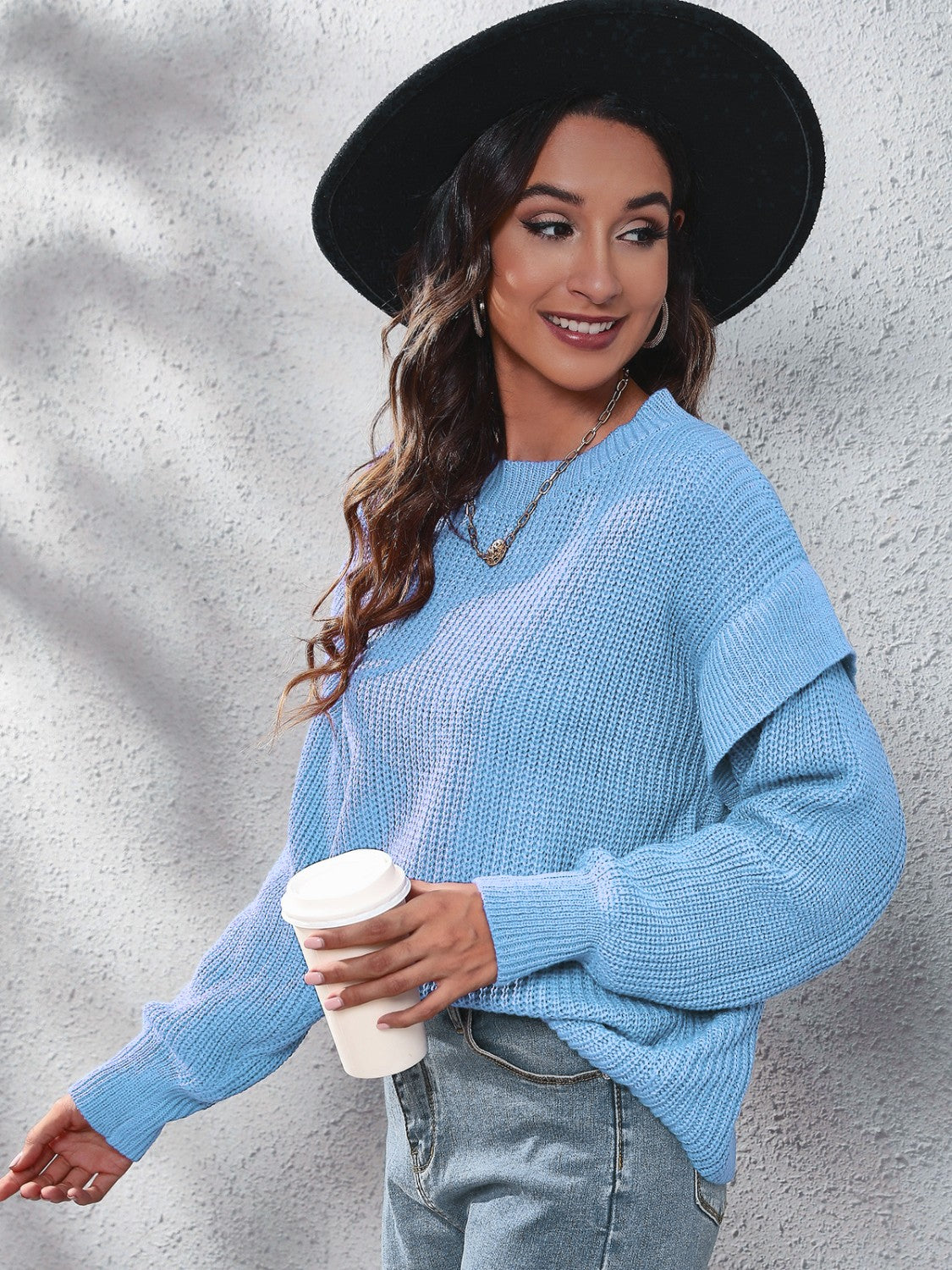 Pastel blue ribbed knit pullover sweater with ruffled sleeves and a crew neck.