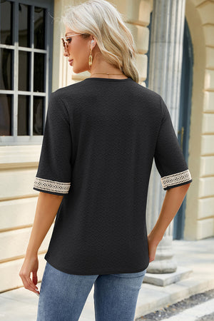 Black textured V-neck top with lace trim on the sleeves.