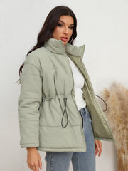 Light green textured puffer jacket with drawstring waist and stand-up collar.