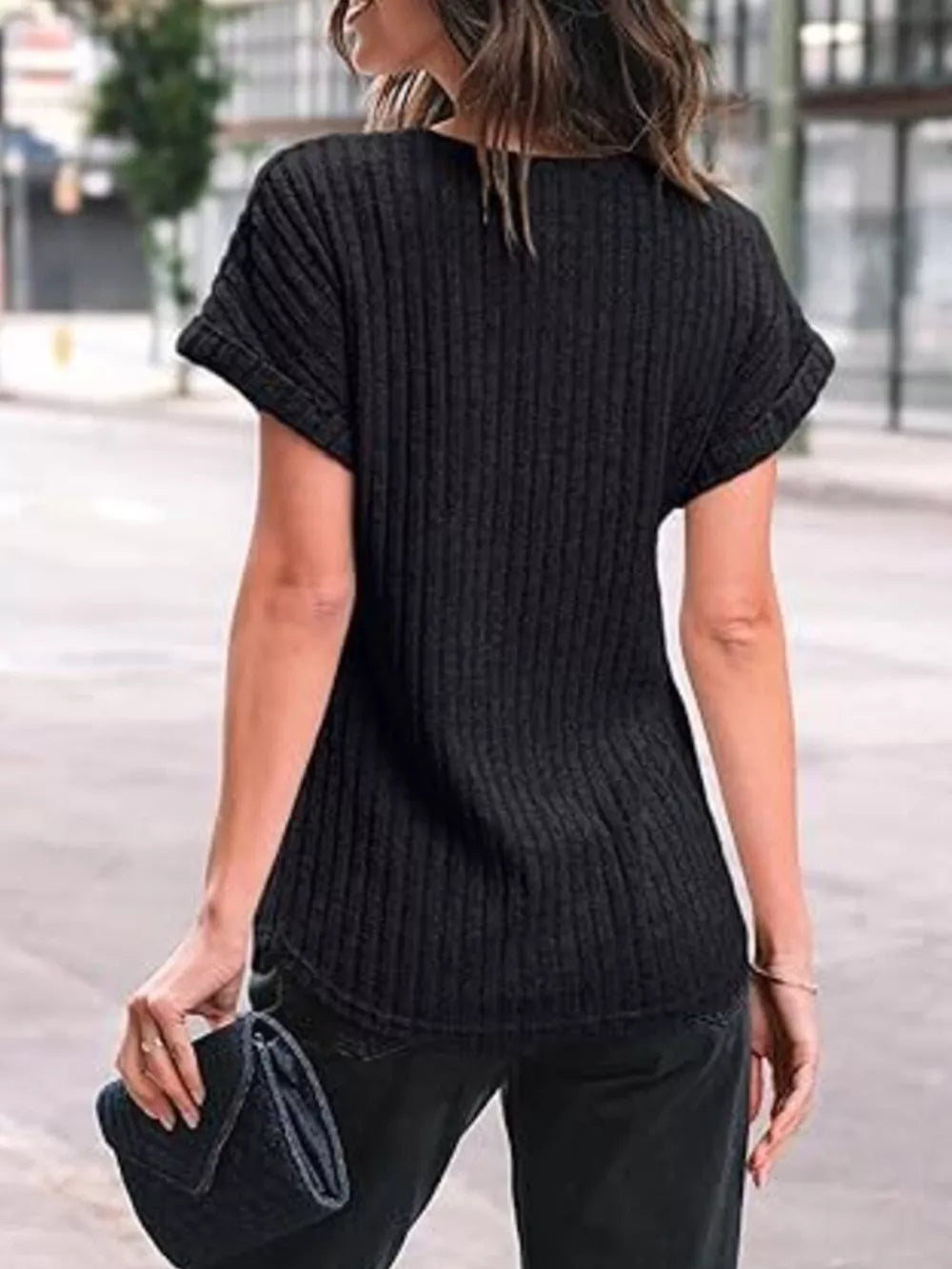 Black ribbed knit t-shirt with cuffed short sleeves and a relaxed fit.