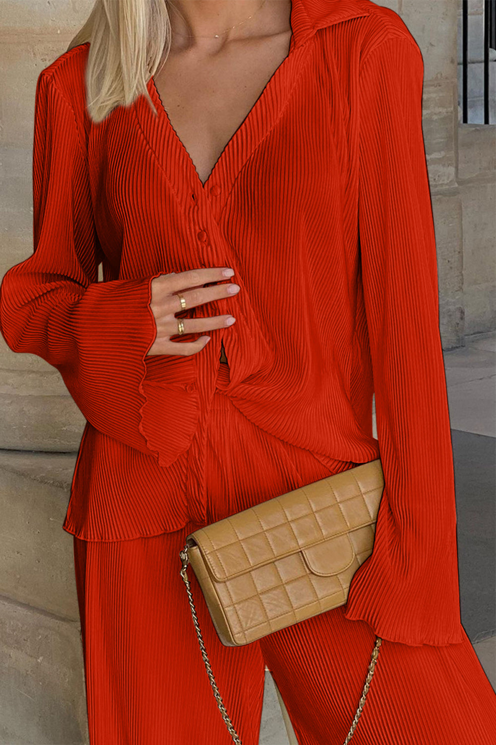 Orange-red pleated shirt and wide-leg trousers set with button detail and flared sleeves.