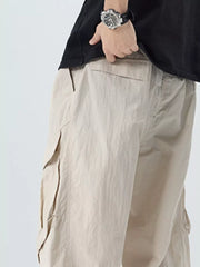 Oversized cargo pants in khaki with large side pockets and adjustable belt detail.