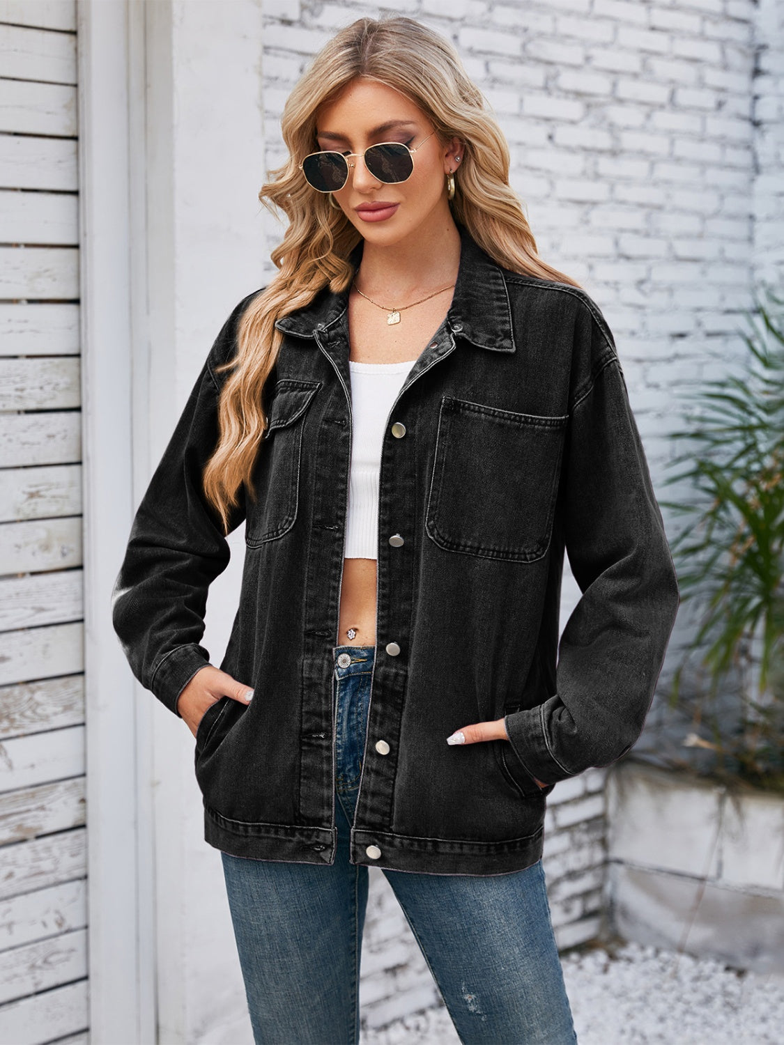 Oversized dark blue denim jacket with hood detail, buttoned front and chest pockets.