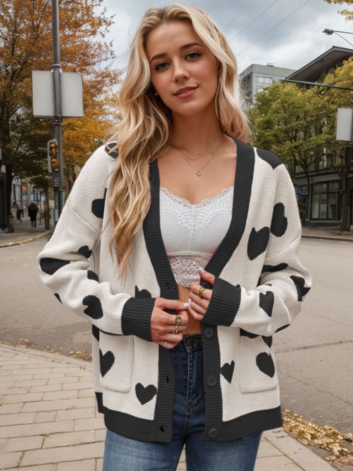 Cream acrylic cardigan with black heart intarsia pattern, button front and pockets.