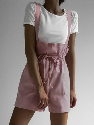 Dusty pink high-waisted drawstring suspender shorts with pockets.