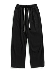 Black wide-leg pleated trousers with drawstring and front pleats