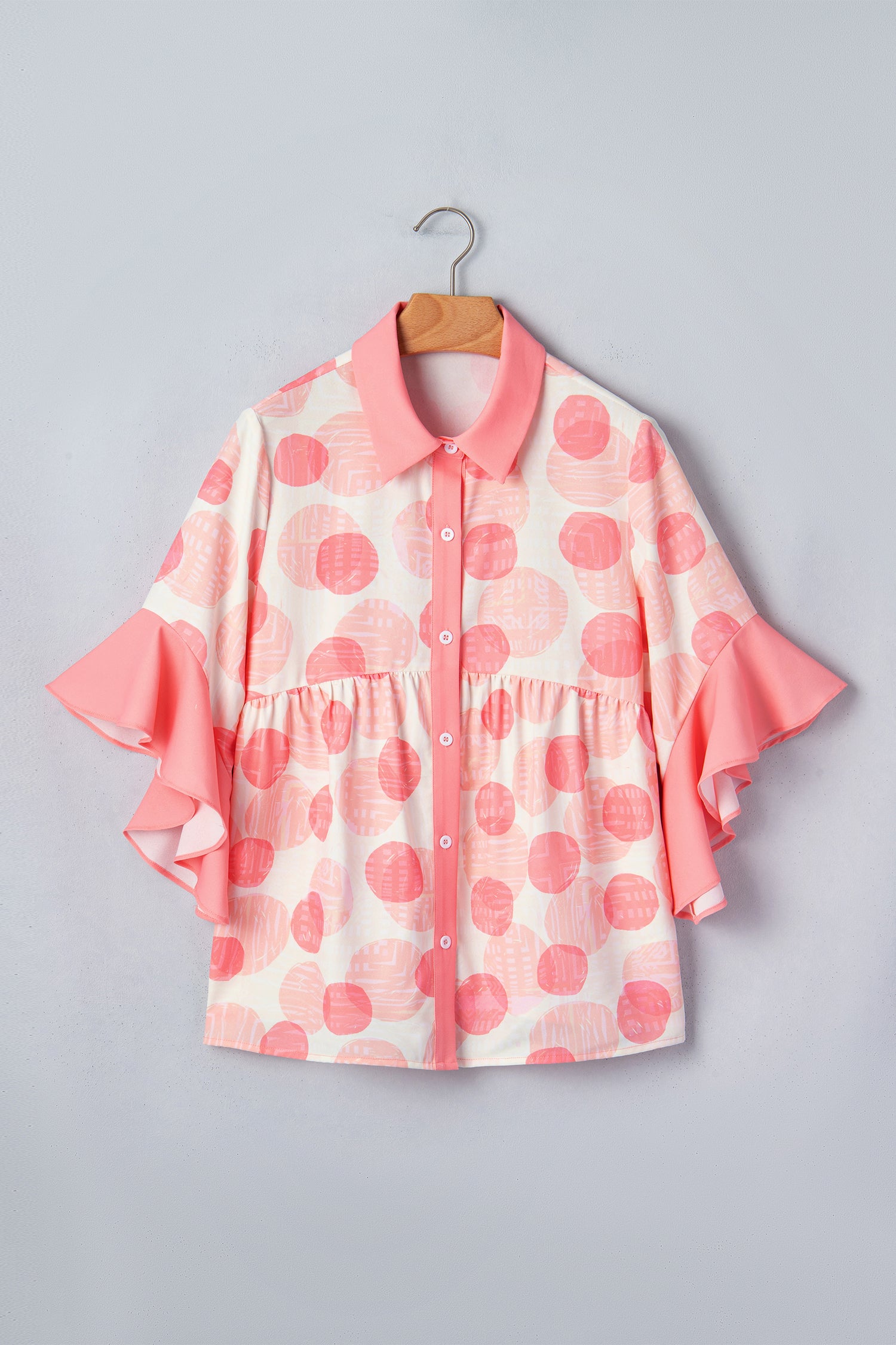 White and pink polka dot babydoll blouse with ruffle sleeves and button front.