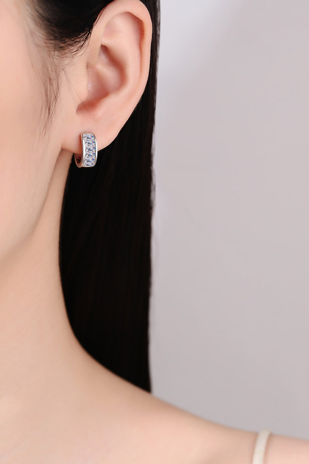 Silver baguette cut crystal huggie hoop earrings with a row of clear crystals.