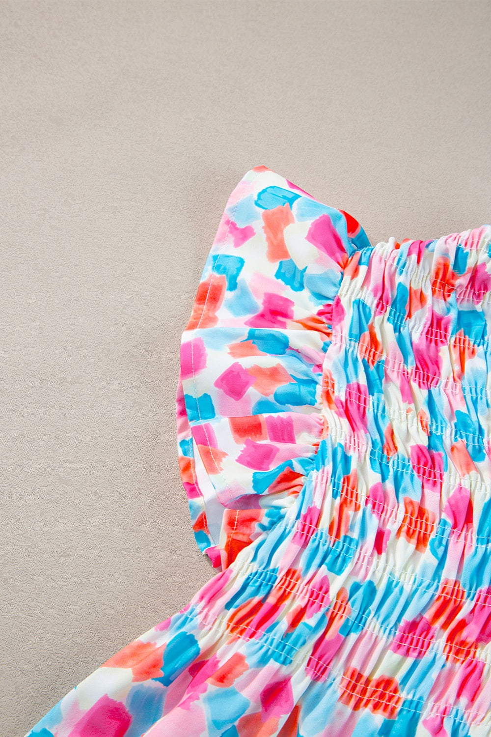Smocked bodice blouse with brushstroke print in pink, blue, and coral.