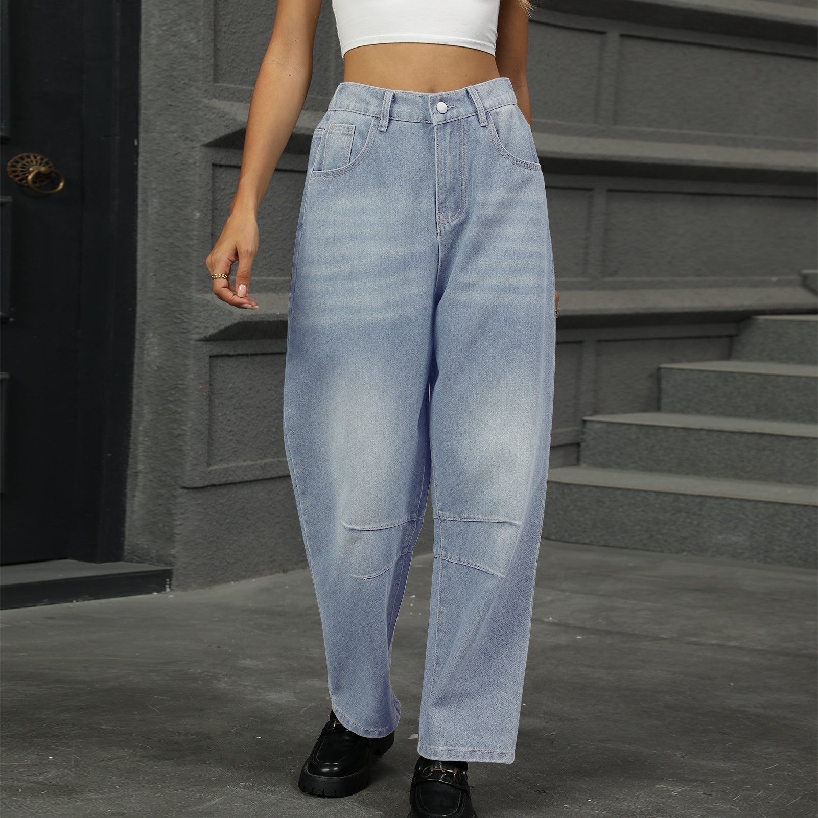 Relaxed light wash denim trousers with patchwork knee details and a wide leg.