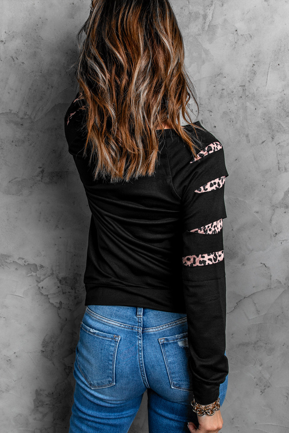 Black sweatshirt with leopard print cutouts on the sleeves.