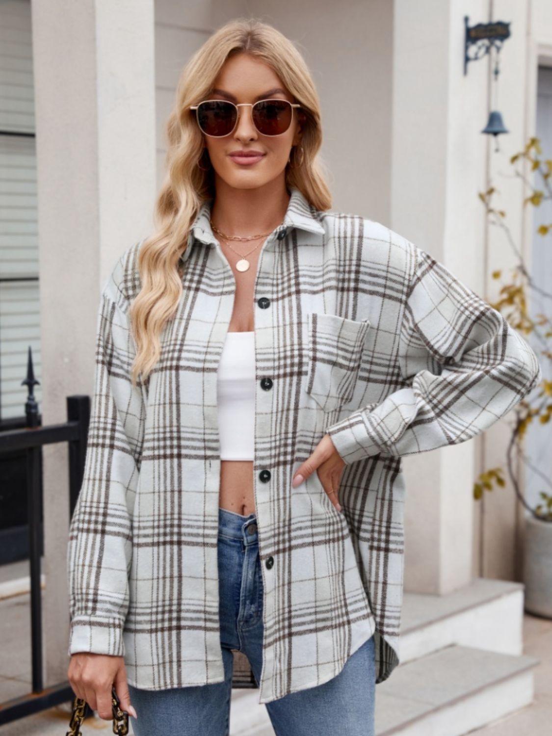 Oversized plaid shirt jacket in white with brown plaid, featuring a pocket and button front.