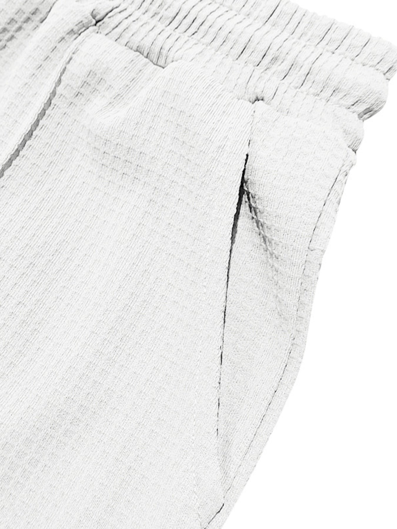 Textured drawstring sweatpants in white with a textured fabric and elastic waistband.