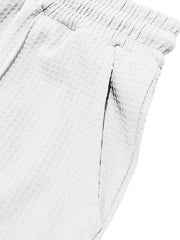 Textured drawstring sweatpants in white with a textured fabric and elastic waistband.