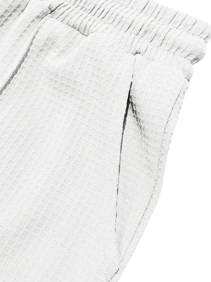 Textured drawstring sweatpants in white with a textured fabric and elastic waistband.