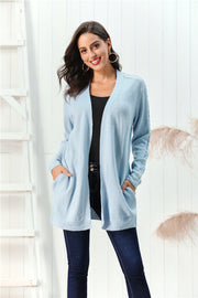 Light blue acrylic cable knit open front cardigan with pockets and braided sleeve detail.