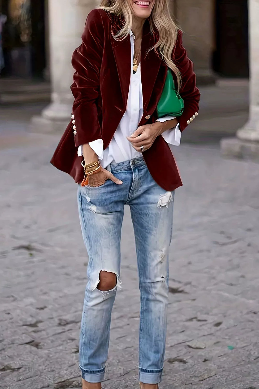 Burgundy velvet blazer with sculpted shoulders and button details, styled with jeans.