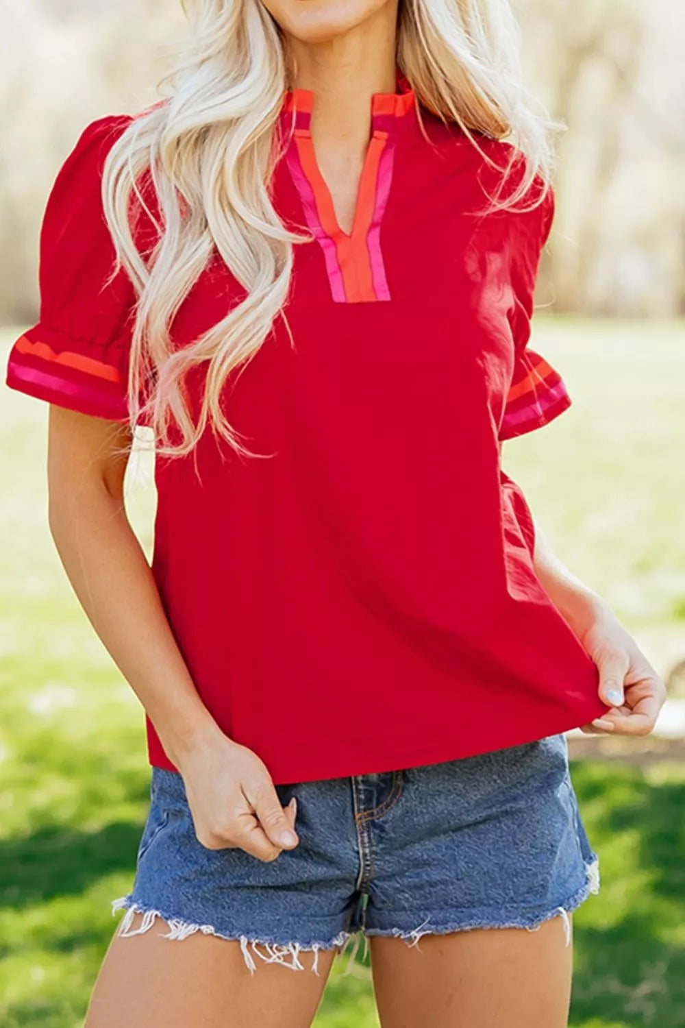 Red maternity blouse with ruffled sleeves and striped V-neck detail.