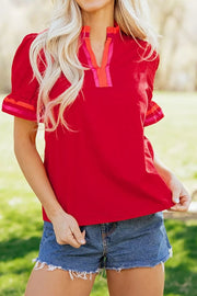 Red maternity blouse with ruffled sleeves and striped V-neck detail.
