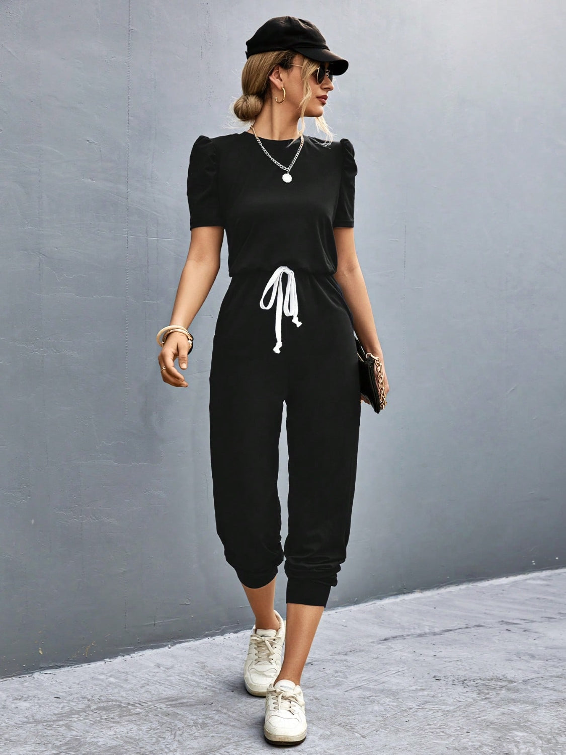 Black jumpsuit with puffed short sleeves, drawstring waist, and cropped legs