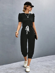 Black jumpsuit with puffed short sleeves, drawstring waist, and cropped legs