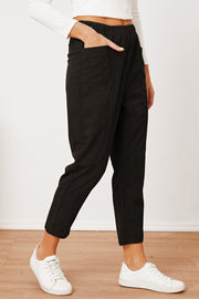 Black corduroy barrel-leg utility pants with elastic waist and side pockets.