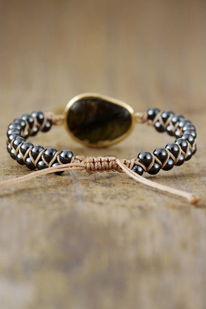 Black beaded bracelet with braided detail and labradorite stone.