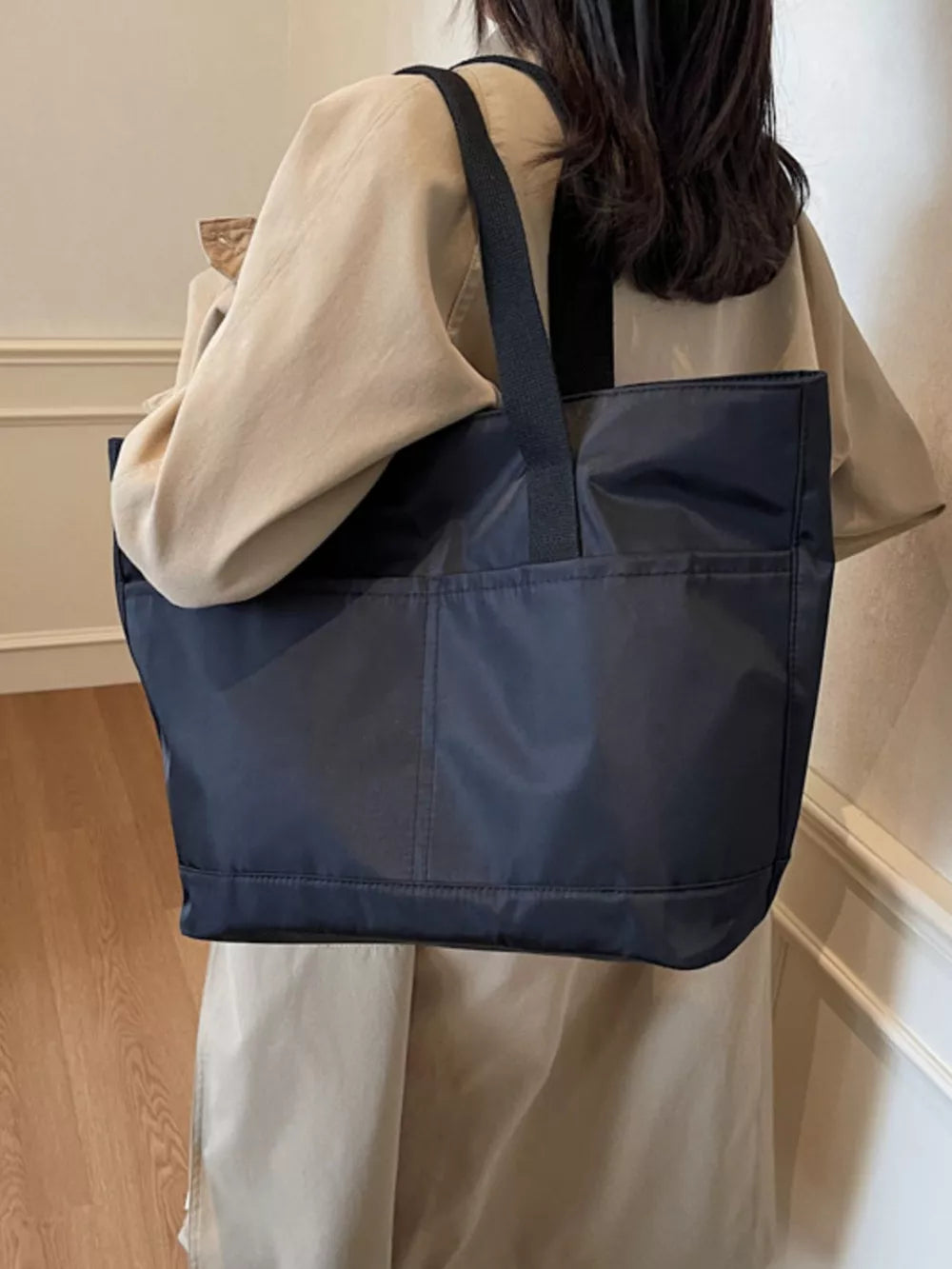 Spacious navy Oxford cloth shoulder tote bag with front pockets and black straps.