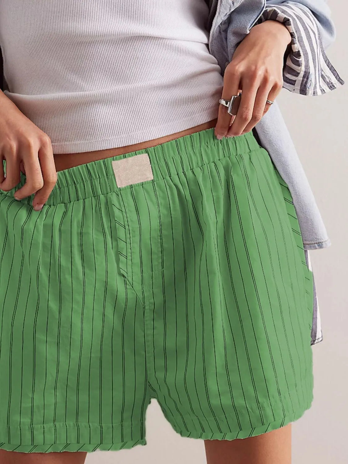 Green striped boxer shorts with elastic waistband and button fly detail.