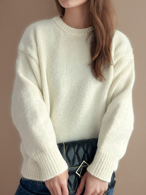 Oversized cream crewneck sweater with textured knit and ribbed cuffs.