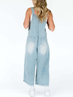 Light blue denim overalls with relaxed fit, ripped details and wide leg cropped length.