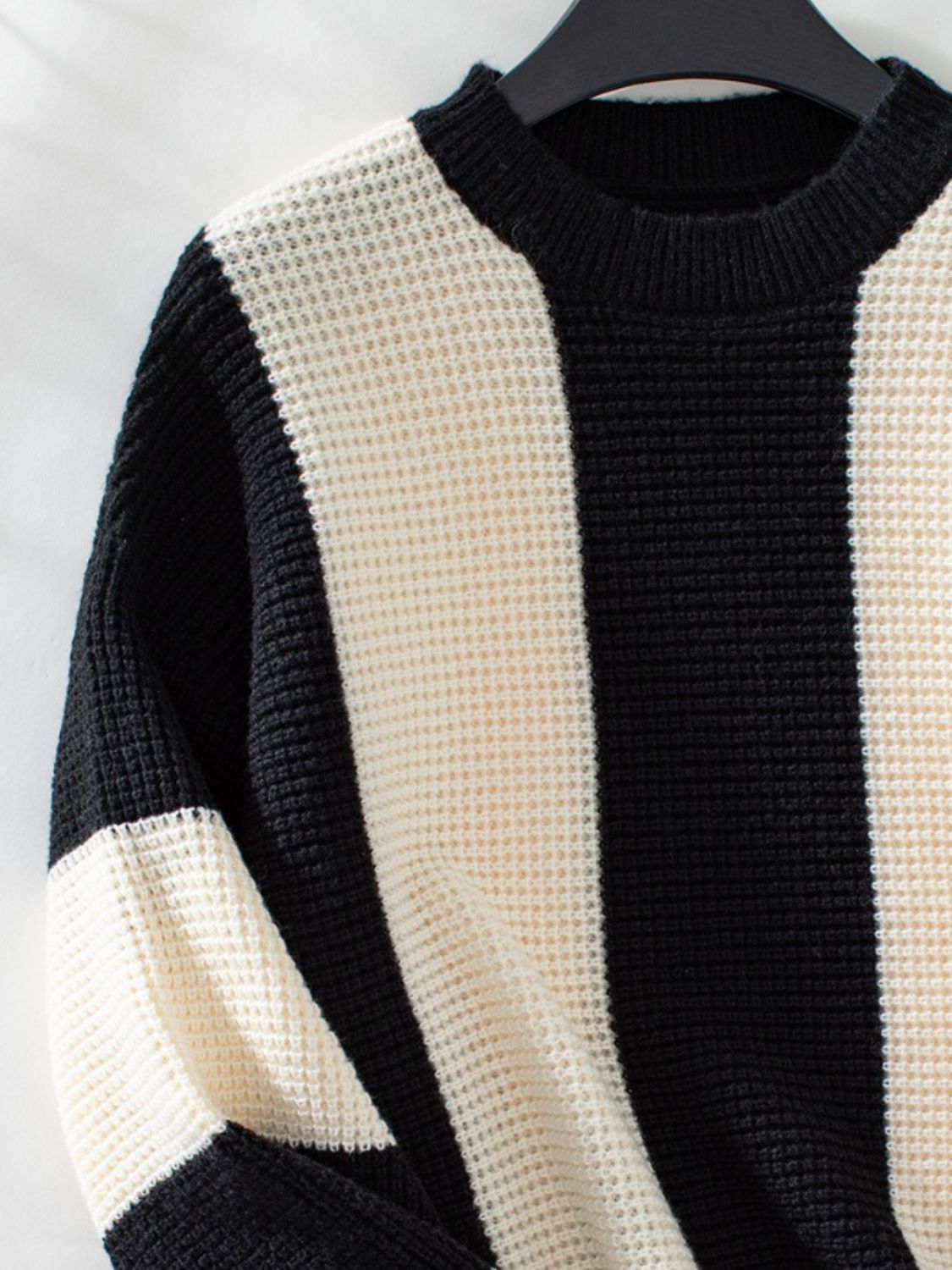 Colorblock stripe knit sweater in black and cream with waffle texture and crew neck.