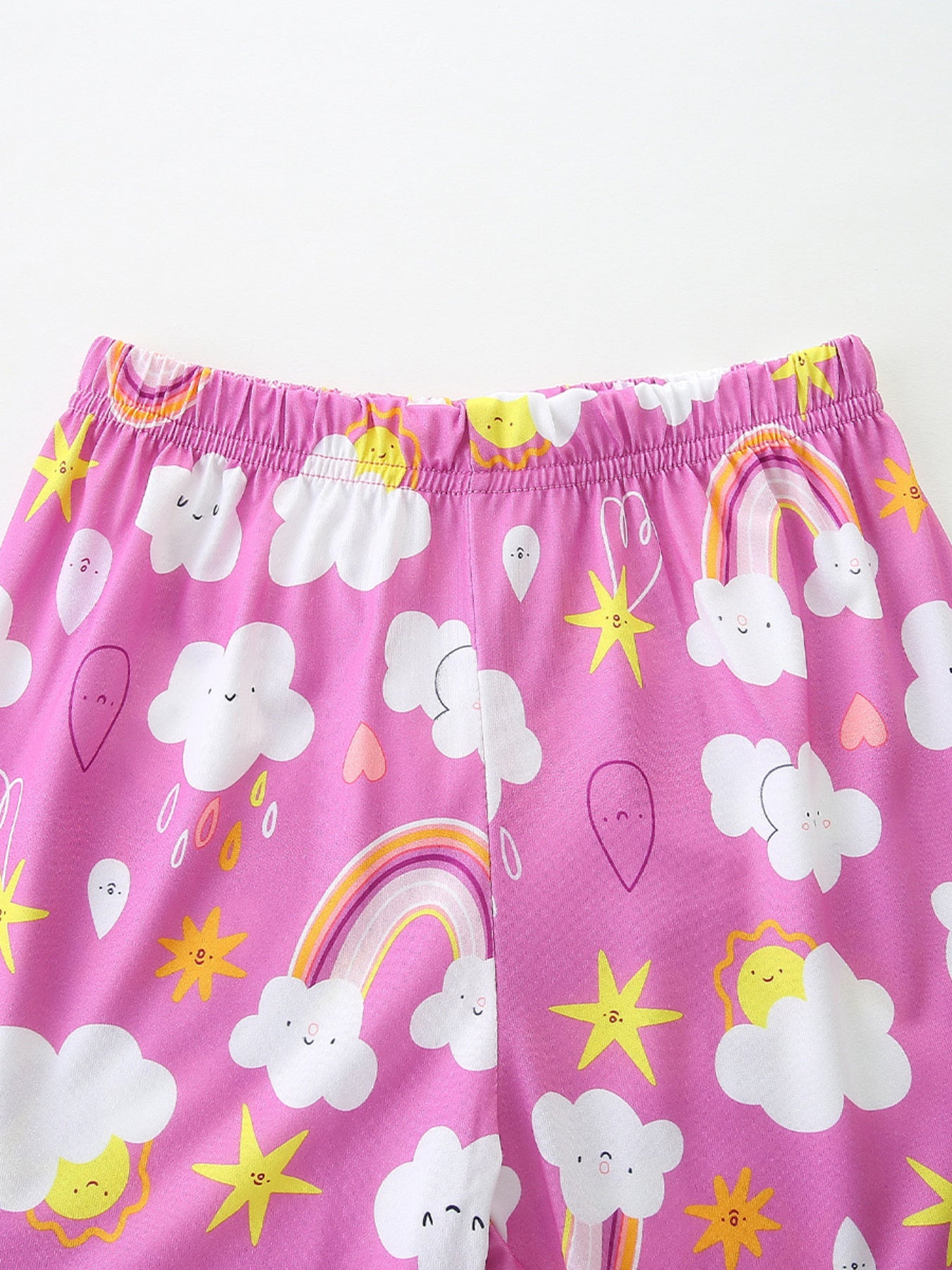 Girls' long johns with elastic waist and a pink background featuring a whimsical cloud, rainbow, sun, and star print.