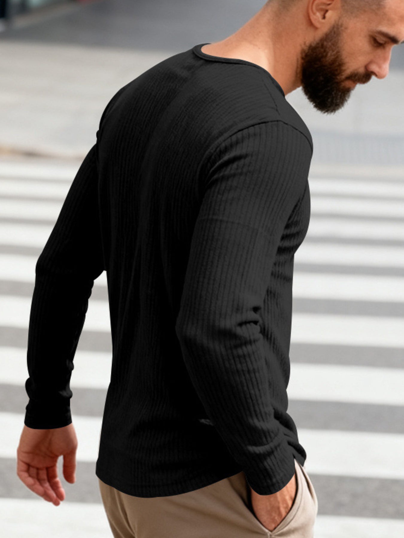 Black ribbed long sleeve t-shirt with crew neck, shown on a man from the side.