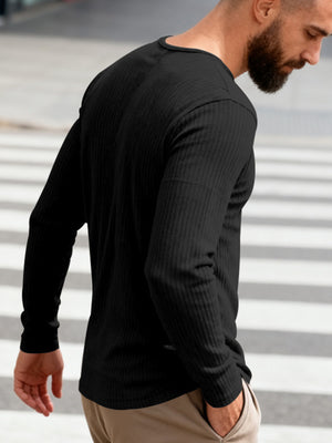 Black ribbed long sleeve t-shirt with crew neck, shown on a man from the side.