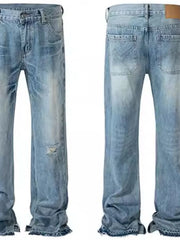 Split-hem distressed denim jeans in medium wash with ripped details and frayed hems.