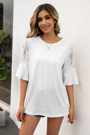 White lace cutout sleeve top with flared bell sleeves and a round neckline.