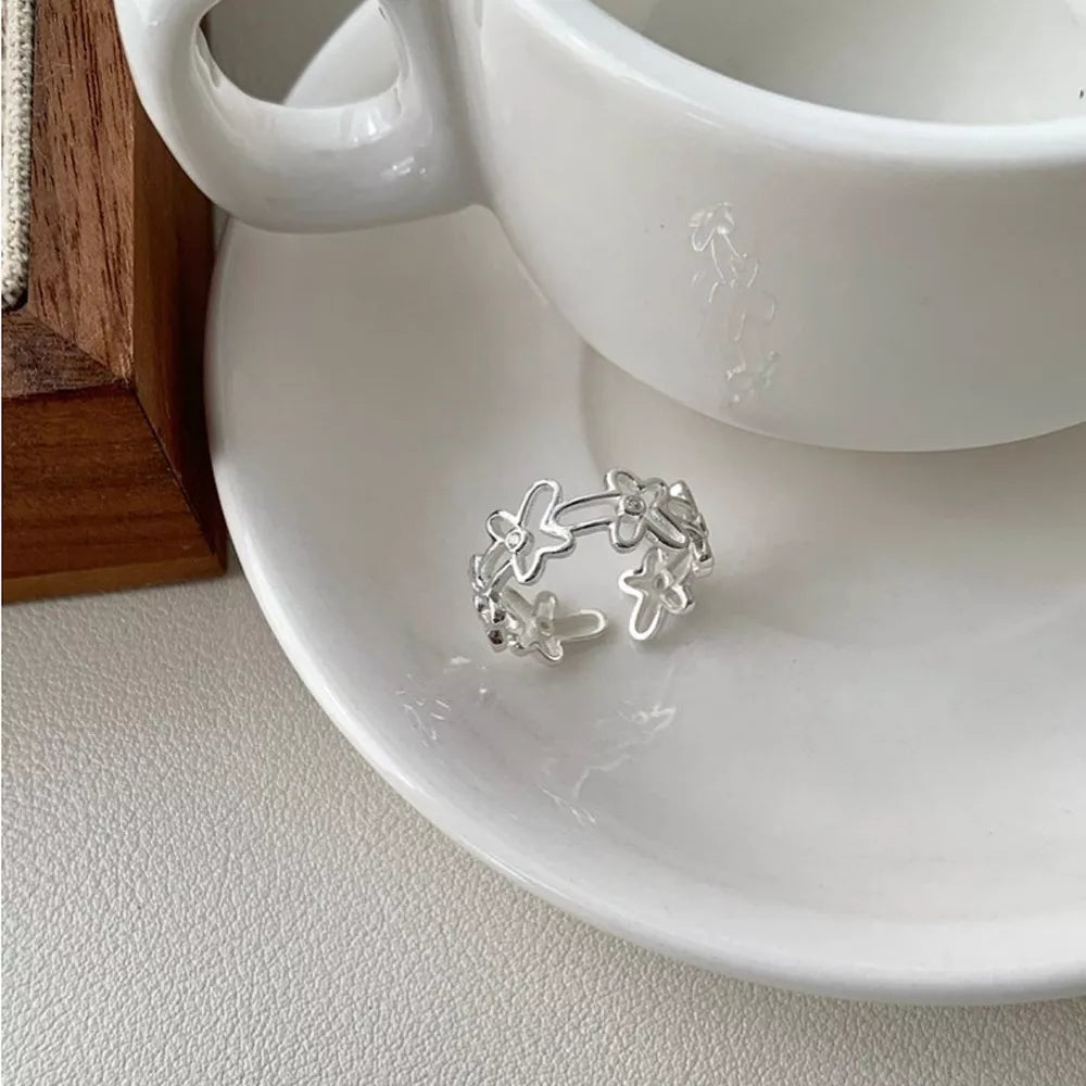 Sterling silver open ring with a delicate floral motif pattern.
