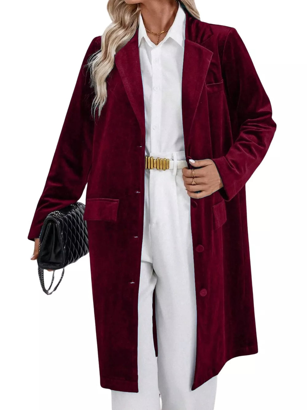 Burgundy velvet longline trench coat with lapel collar and buttoned front, worn with white pants.
