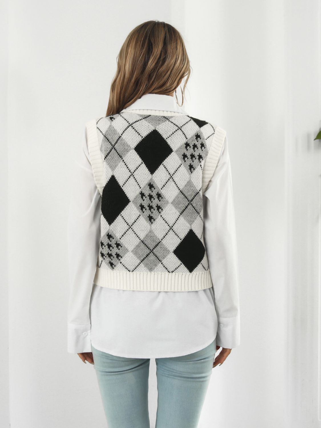 Argyle knit cropped sweater vest in white with black and grey diamond pattern.