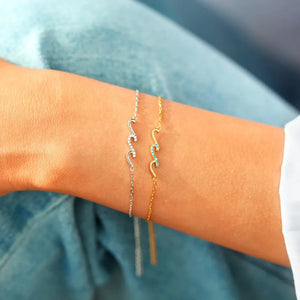 Ocean Wave Zirconia Bracelet in gold with turquoise stones and silver with clear stones.