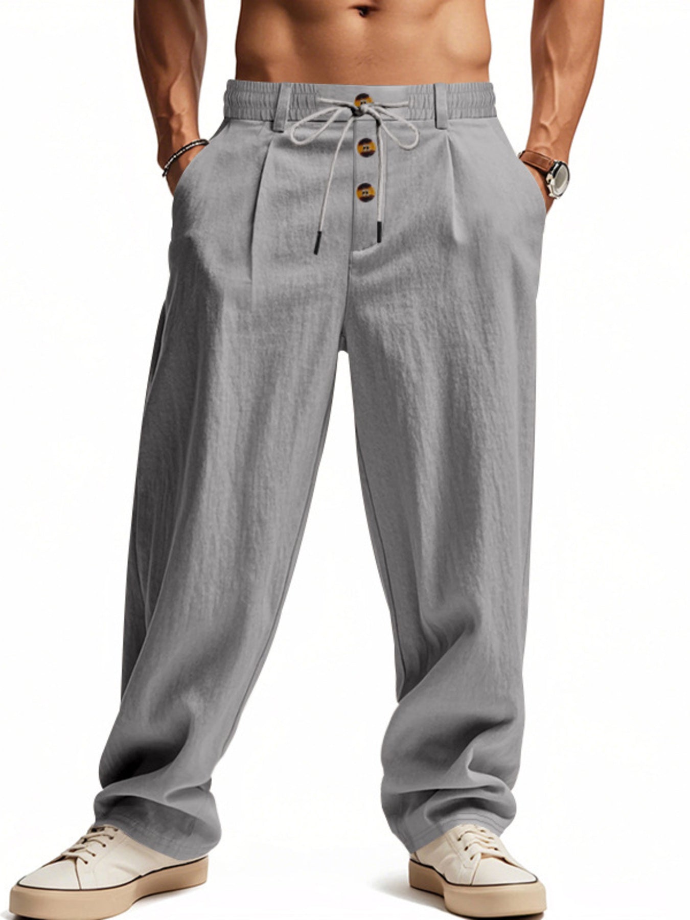 Men's grey loose fit drawstring pants with button fly detail and pleats.