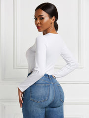 White long sleeve ribbed bodysuit with a crew neck, paired with blue denim jeans.