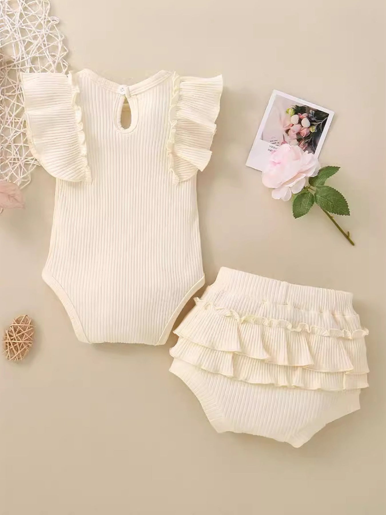 Ribbed baby set in cream with ruffled sleeves and bloomers.