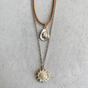 Layered necklace set with silver cowboy hat charm and gold sunflower charm with clear stones.